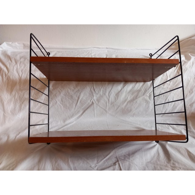 • Design: Designed by Nisse and Kajsa Strinning (first presented in 1949). • Materials: Teak-veneered wooden boards and...