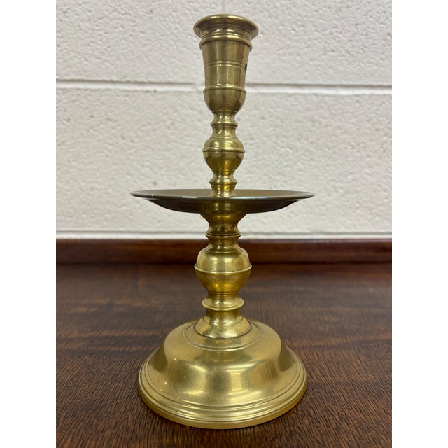 This is a gorgeous antique brass candlestick or chamberstick. Features a turned baluster stem, wide circular drip pan, and...