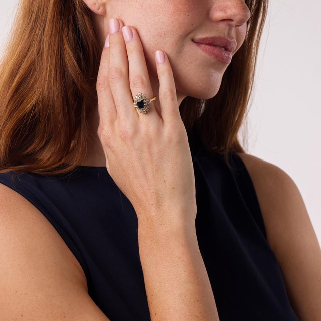 This elegant vintage sapphire and diamond ring is a sophisticated 1980’s design, centered by a GIA-certified emerald cut...