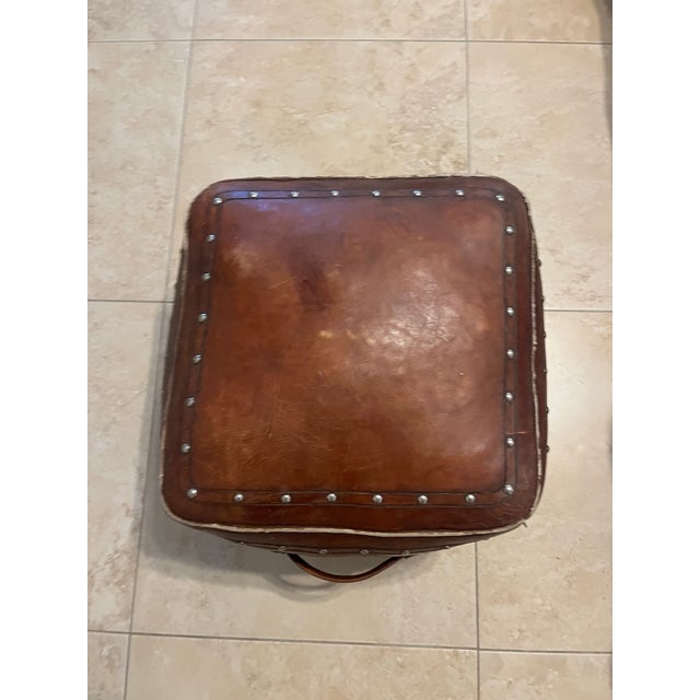 A unique vintage-style square genuine leather rustic pouf ottoman. Great to use as foot stool, extra seating or a fun...