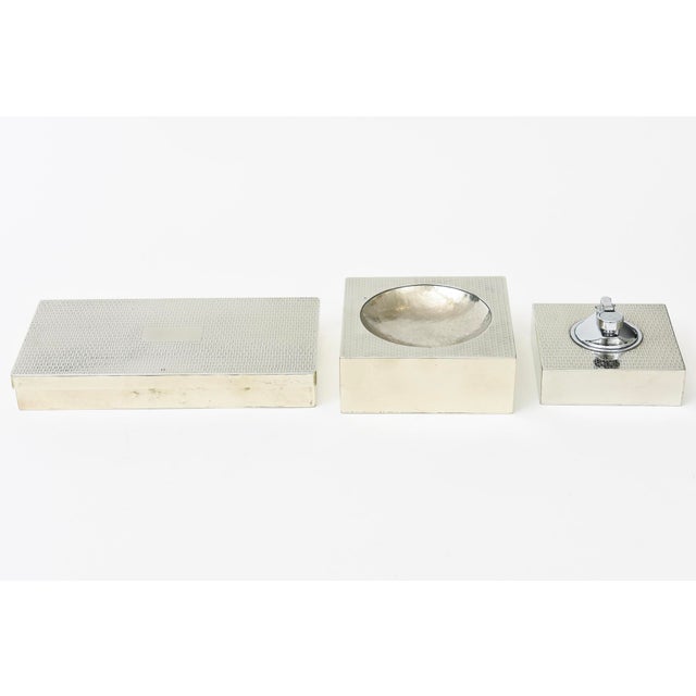 This vintage 3 piece silver -plate Italian desk set of a rectangular lidded box, bowl and lighter has a textural embossed...