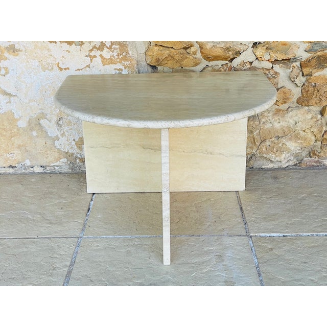 Vintage, half-moon side table/ end table/ small console table. Made of a cream colored travertine, the table features a...
