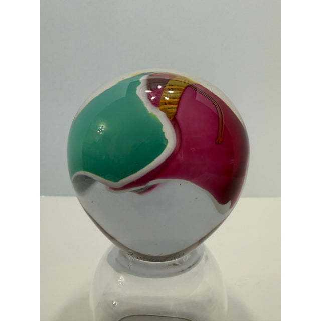 Hand-blown studio art glass paperweight signed “James R. Wilbat Jr” on the base. This piece features a vibrant abstract...