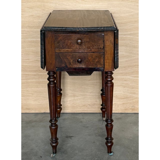 This elegant 19th-century Victorian drop-leaf side table is crafted in richly toned wood, showcasing the warm colour and...