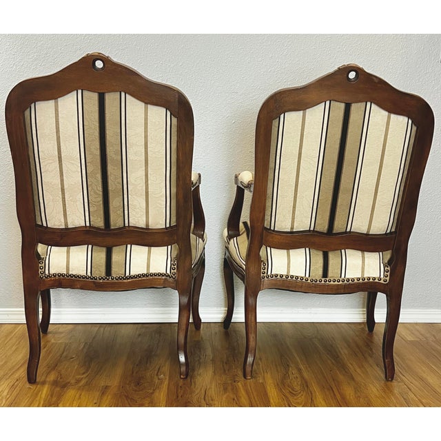 An exceptional matching pair of Louis XV–style walnut fauteuil armchairs (c. 1880–1900), restored with rare attention to...