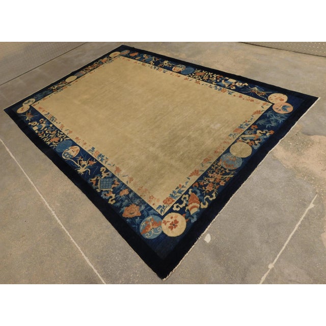 Antique chinese rug. Plain beige field with blue border.