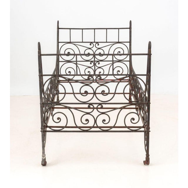 French Wrought Iron Folding Campaign Bed, with scroll form motif on casters. 40.25" H x 33.5" W x 75.5" D. Provenance:...