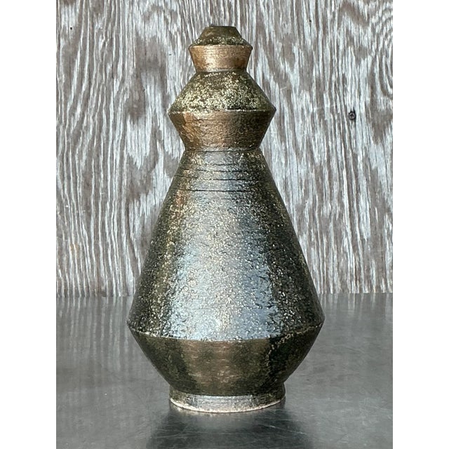 This striking vintage studio pottery vase is a true testament to handcrafted artistry, featuring a unique geometric form...