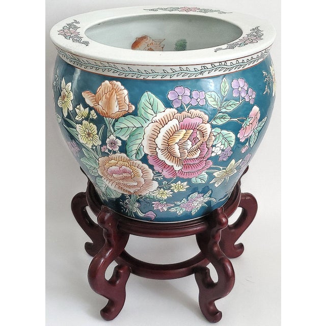 Offering a vintage porcelain teal colored gold fish bowl planter with pink peonies and lavender violets with wood stand,...