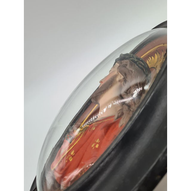 A unique, three-dimensional depiction of the Sacred Heart of Jesus, crafted as a polychrome plaster relief and set in a...