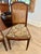 Imported French Louis XVI walnut cane back dining chairs with floral tapestry upholstery and nail head trim. These chairs...