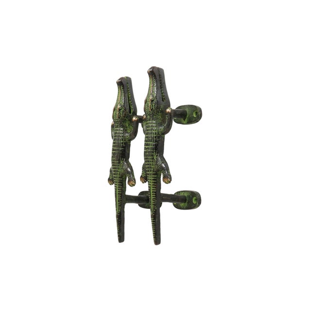 A pair of green brass alligator door handles or cabinet pulls. Pressed with simple details to convey skin, eyes and toes....