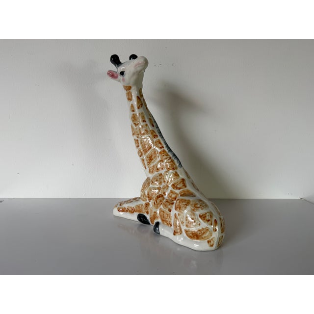 Bring a touch of playful charm to your décor with this vintage hand-painted ceramic giraffe sculpture from the 1980s....