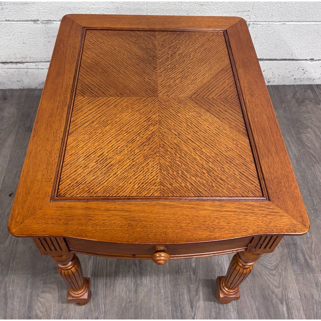 This is a traditional Broyhill wood end table featuring a warm brown finish, decorative fluted and turned legs, bun feet,...