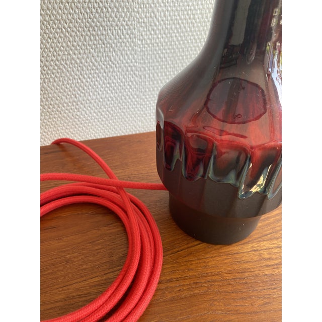 A striking ceramic table lamp by ernst nielsen for ernst faxe keramik, denmark. The deep oxblood glaze — running from...