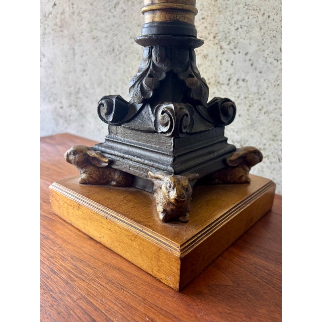 A highly decorative pair of vintage Hollywood Regency table lamps featuring richly carved wood stems accented by gilt...