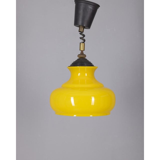 Chandelier with black metal and gold-plated brass structure, yellow glass lampshade, 1970s, Italian design. Up to 250V...