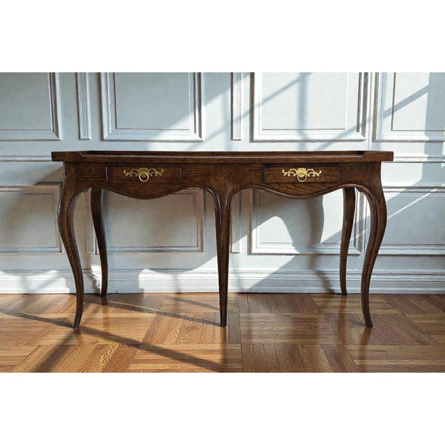 Baker Milling Road Console Table. Features French Country styling framed in oak or tiger oak with a book-matched burlwood...