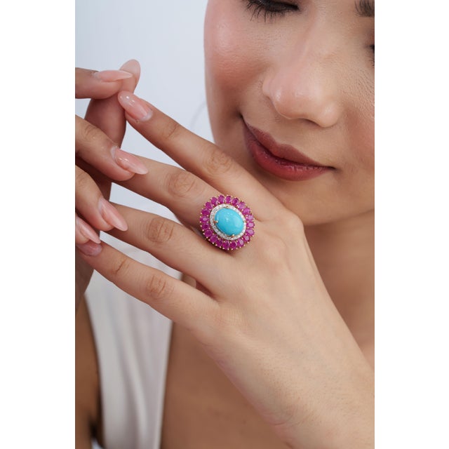 This statement ring features a 9.35-carat oval cabochon turquoise and rubies set in 14k yellow gold. The center turquoise...