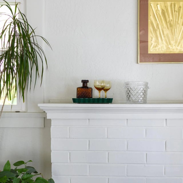 A thick crystal ice bucket featuring tab handles and a repeating diamond pattern trimmed with a band of arches, with a...