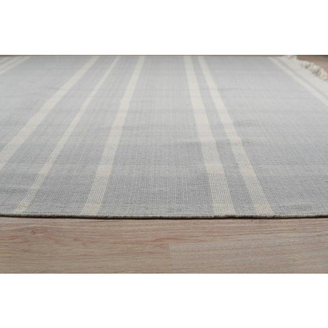 This hand knotted pile rug is crafted from wool and originates from India. The primary color palette consists of neutral...