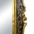 A dramatic chinoiserie mirror in black and gold — glossy black framing with gilded Oriental detailing that glows against...
