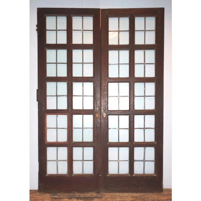C. 1910 pair of 10 light French double doors with leaded glass panes. Doors are done in beautiful dark chestnut and have...