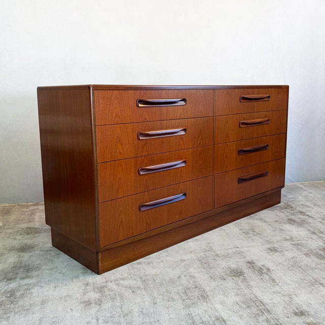 Two banks of four full-width drawers, each fitted with the sculpted solid teak handles characteristic of the Fresco range....