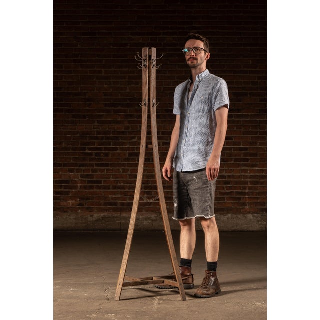 Oak floor-standing coat rack featuring a four-sided central standard fitted with cast metal double hooks arranged at...
