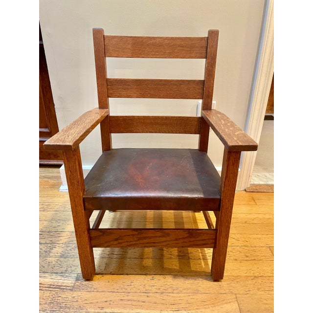 Ladder back design with original label to underside and original nailhead brown leather seat. Circa 1898-1918