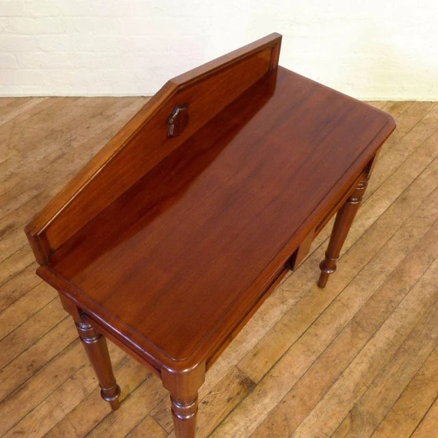 This is an attractive Victorian mahogany side table of small proportions. It's set with a classical backrail with applied...