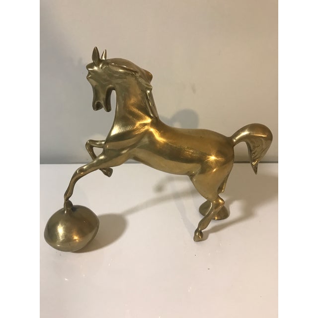 This brass horse sculpture is a stylized depiction, characteristic of mid-20th century design. It is crafted from solid...
