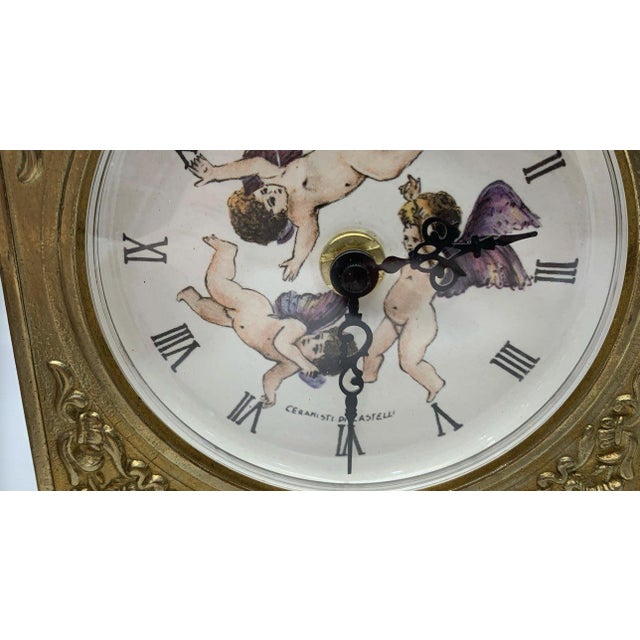An ornate and romantic Italian mantel clock featuring a ceramic dial signed “Ceramisti di Castelli,” referencing the...