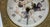 An ornate and romantic Italian mantel clock featuring a ceramic dial signed “Ceramisti di Castelli,” referencing the...