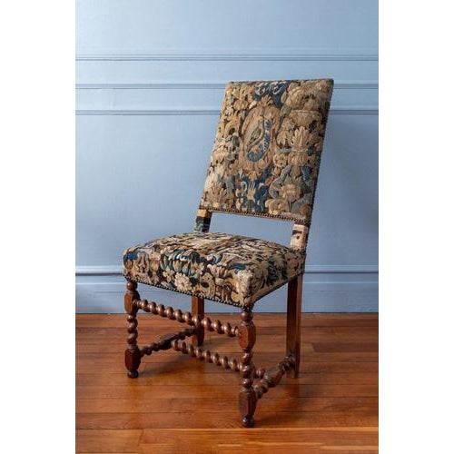 This 17th-century French Louis XIII walnut side chair features a finely turned frame with elaborate barley-twist legs and...