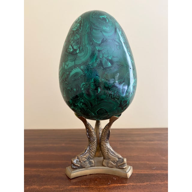 A stunning Russian style monumental malachite egg on Neoclassical style brass stand featuring three dolphins Late 20th...