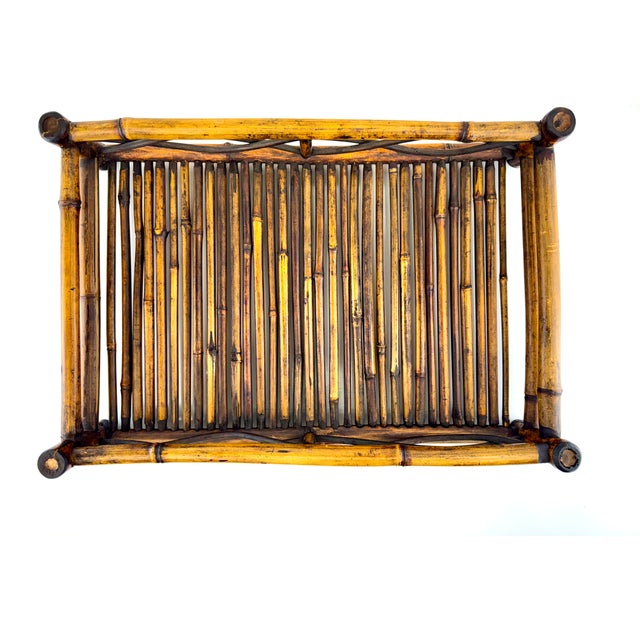 This vintage bamboo tray is constructed from bundled cane rods with a natural aged patina, framed by thicker bamboo poles...