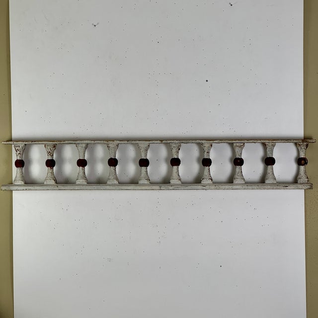 Architectural salvaged wooden balustrade/railing portion in its original white paint with red knots for the hourglass...