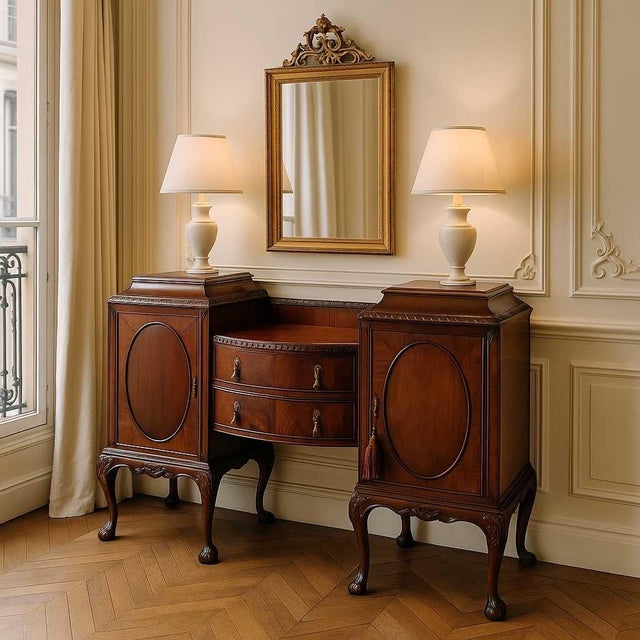 An antique Chippendale-style mahogany sideboard with carved floral details, egg-and-dart trim, and elegant claw-and-ball...