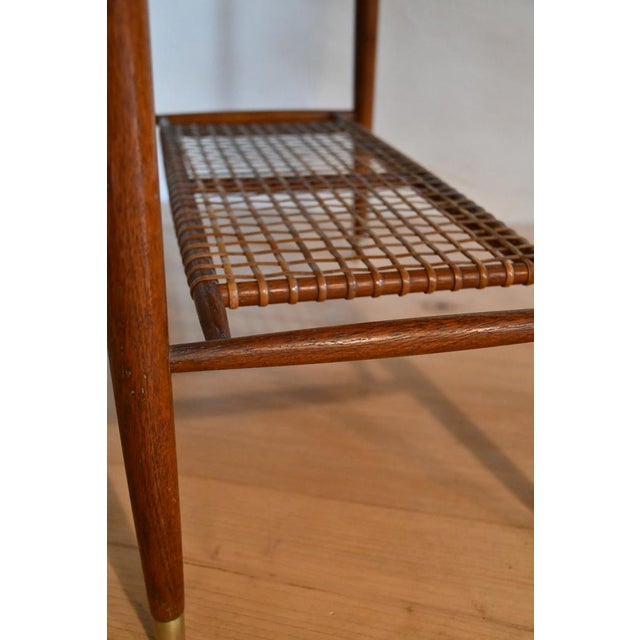 Bertil Fridhagen for Bodafors Coffee table with a rhomboid teak top Tapered base with brass feet joined by a rattan...