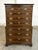 This Drexel 18th Century Collection chest of drawers features a tall build with richly figured wood veneers, contrasting...