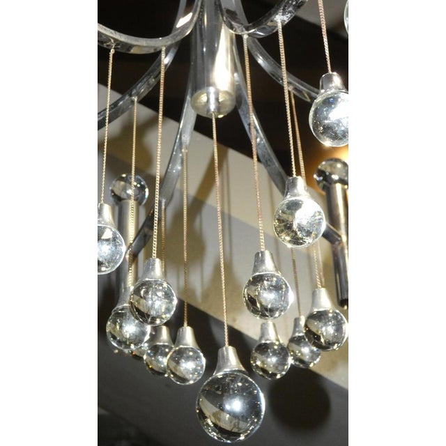 Elegant six-light chandelier produced in the early 1970s in chrome-plated steel and crystal, the work of master angelo...