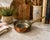 Antique copper butter warmer or small saucepan with a tin-lined interior and riveted brass handle. The piece has a warm...