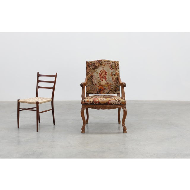 A richly expressive Louis XV–style armchair in carved walnut, crafted in France around 1900 and tailored to the refined...