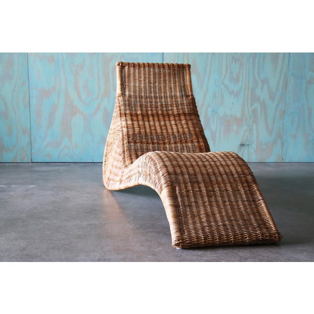 A Karlskorna chaise lounge chair designed by Karl Malmvall for Ikea c. 1990s. Woven rattan in a sculptural form that hugs...