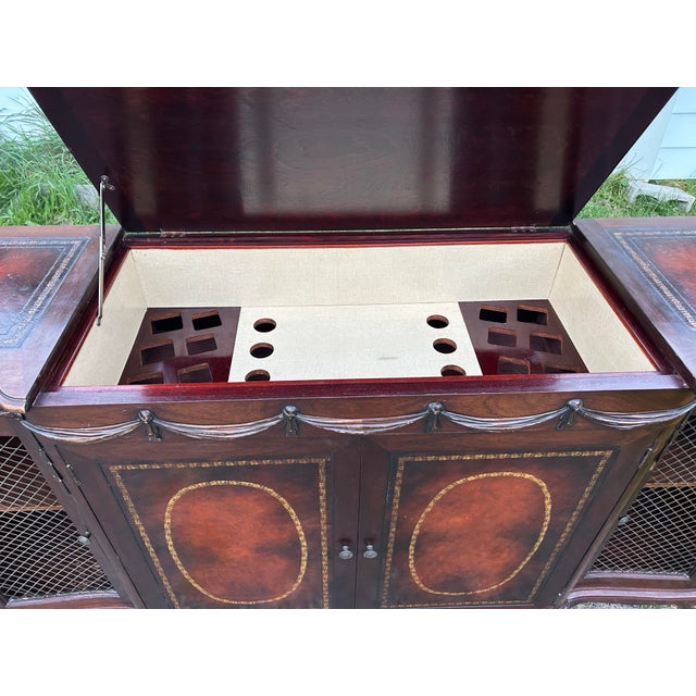 This is a statement piece. The front has two hand-tooled leather door panels with gold oval and floral borders, and carved...