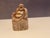Cheerful hand‑carved figure of Budai, known as the Laughing Buddha, seated in relaxed repose. The piece features smooth...