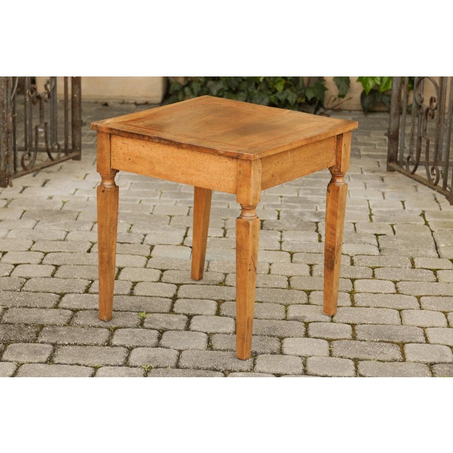 An Italian walnut neoclassical period side table from circa 1820, with single drawer and tapered legs. Born in Italy...
