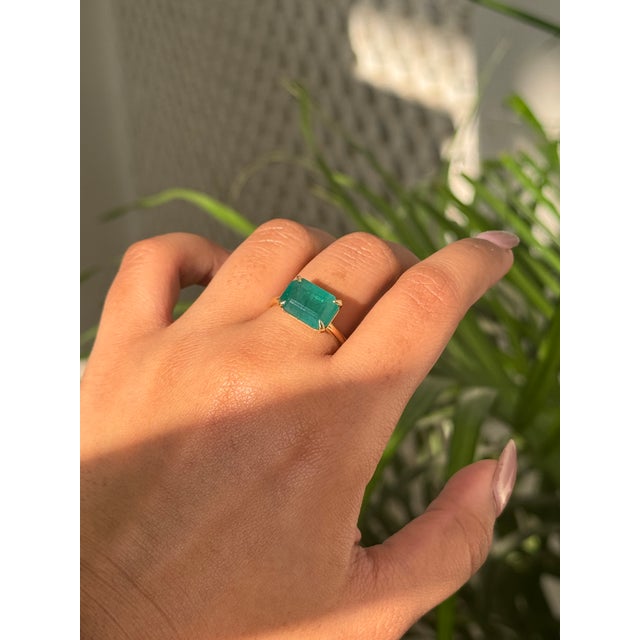 This striking 4.42 carat emerald-cut emerald cocktail ring is crafted in 18K yellow gold. The emerald, measuring about...