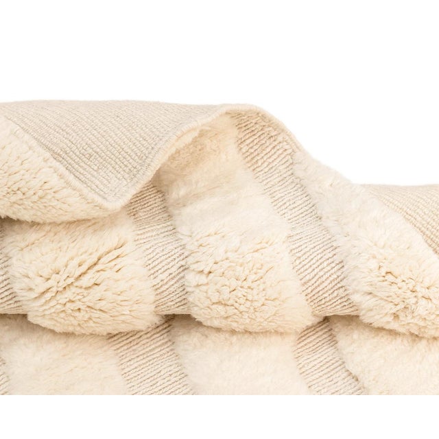 Sumptuous crafted wool rug with a Hand-knotted pile and Flat-woven base, in soothing shades of Ivory and Natural Wool,...